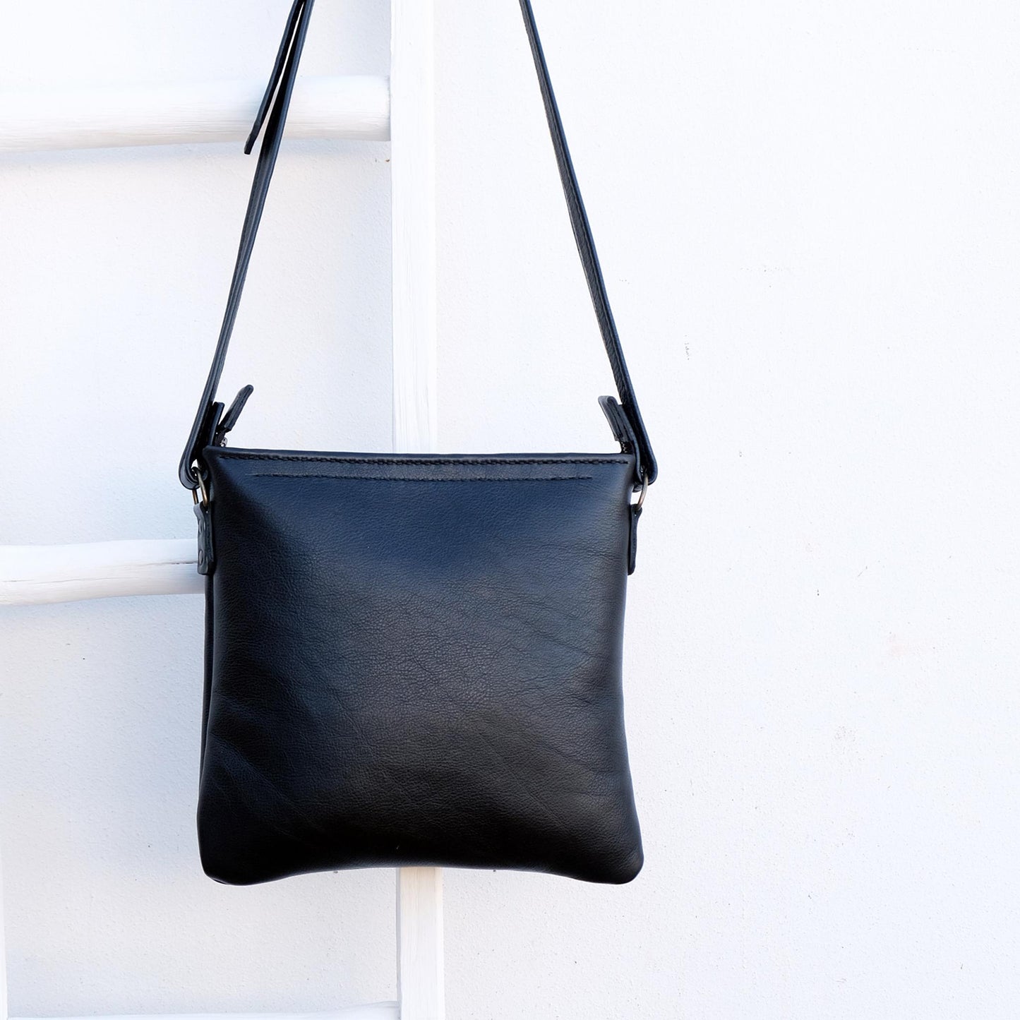 Cross over black leather satchel back